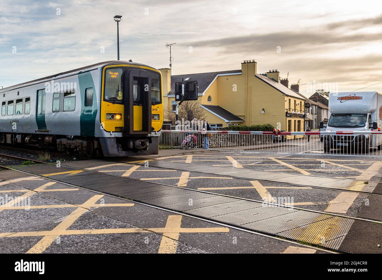 Iarnród Éireann passenger train passes a level crossing in Midleton, East Cork, Ireland. Stock Photo
