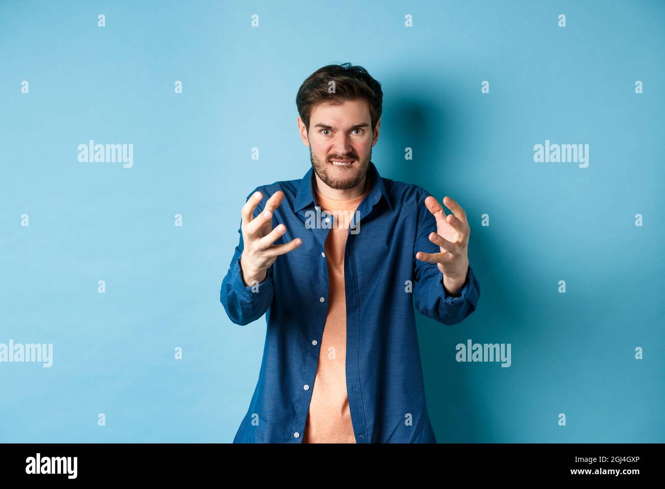 Angry tensed man wants to strangle someone, stretch out hands to choke