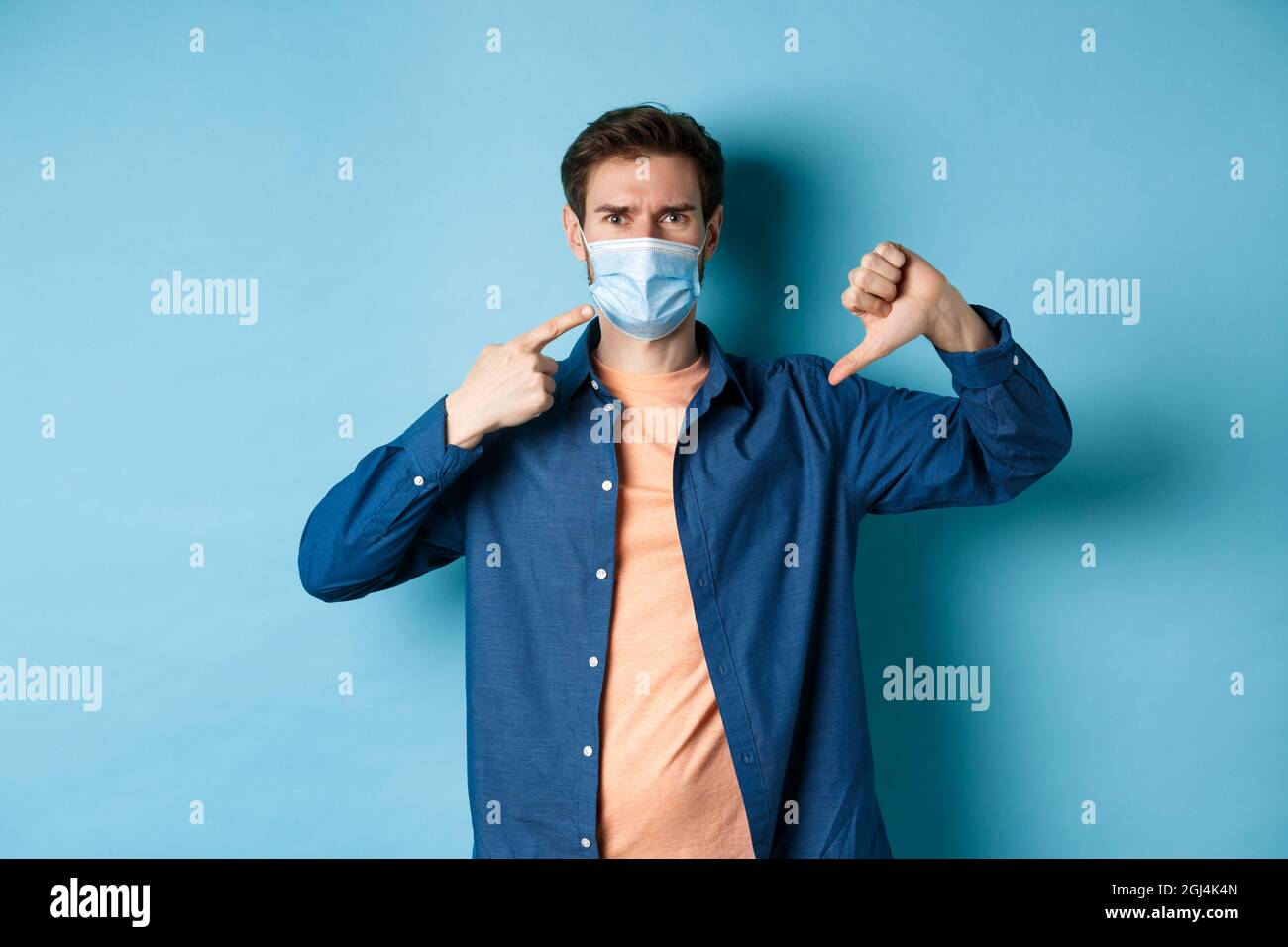 Coronavirus and pandemic concept. Disappointed young man pointing at ...