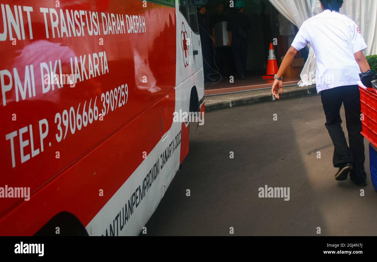 The health worker got out of the car and headed to the room carrying equipment to prepare for a blood donation event held in an office. Stock Photo