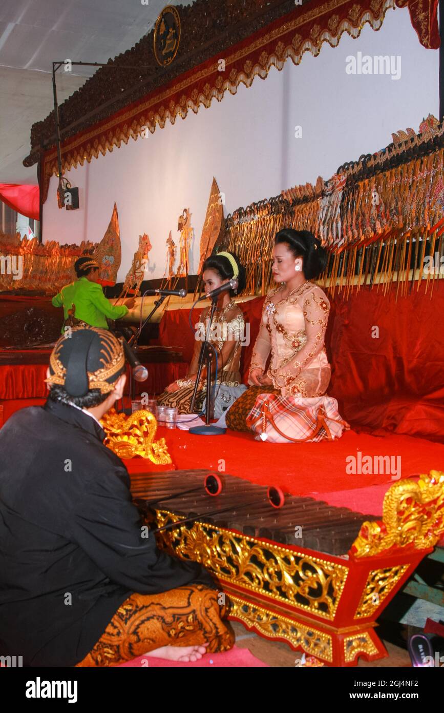 A Javanese wayang kulit performance, there is a dalang and a gambang or xylophone player and two sinden, or traditional singers. Stock Photo
