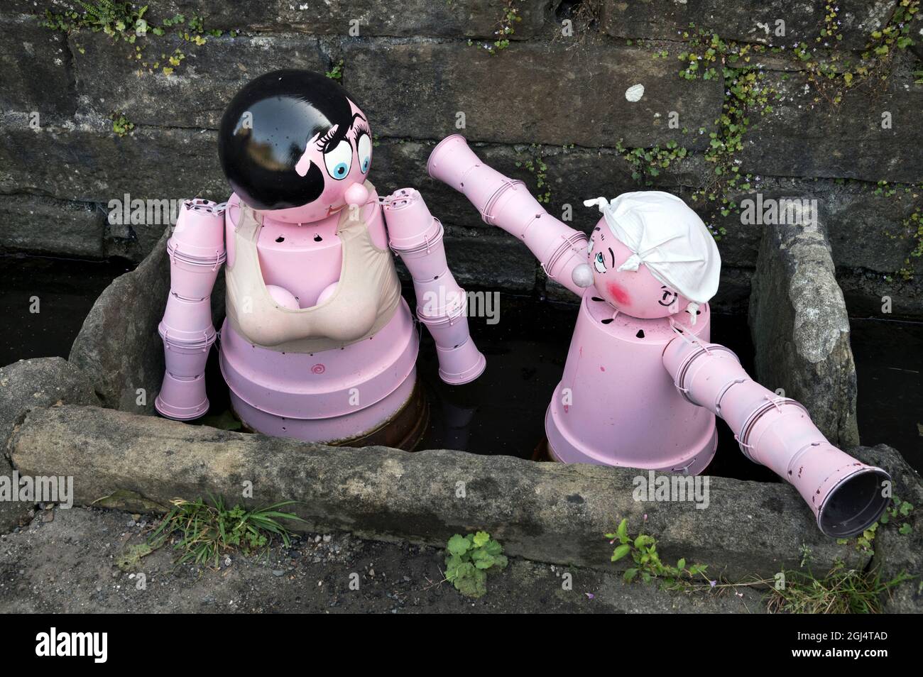 Settle, North Yorkshire, Flowerpot Festival, 2021. Bathing figures based on old Bamforth's saucy postcards, located in the old town well water troughs Stock Photo