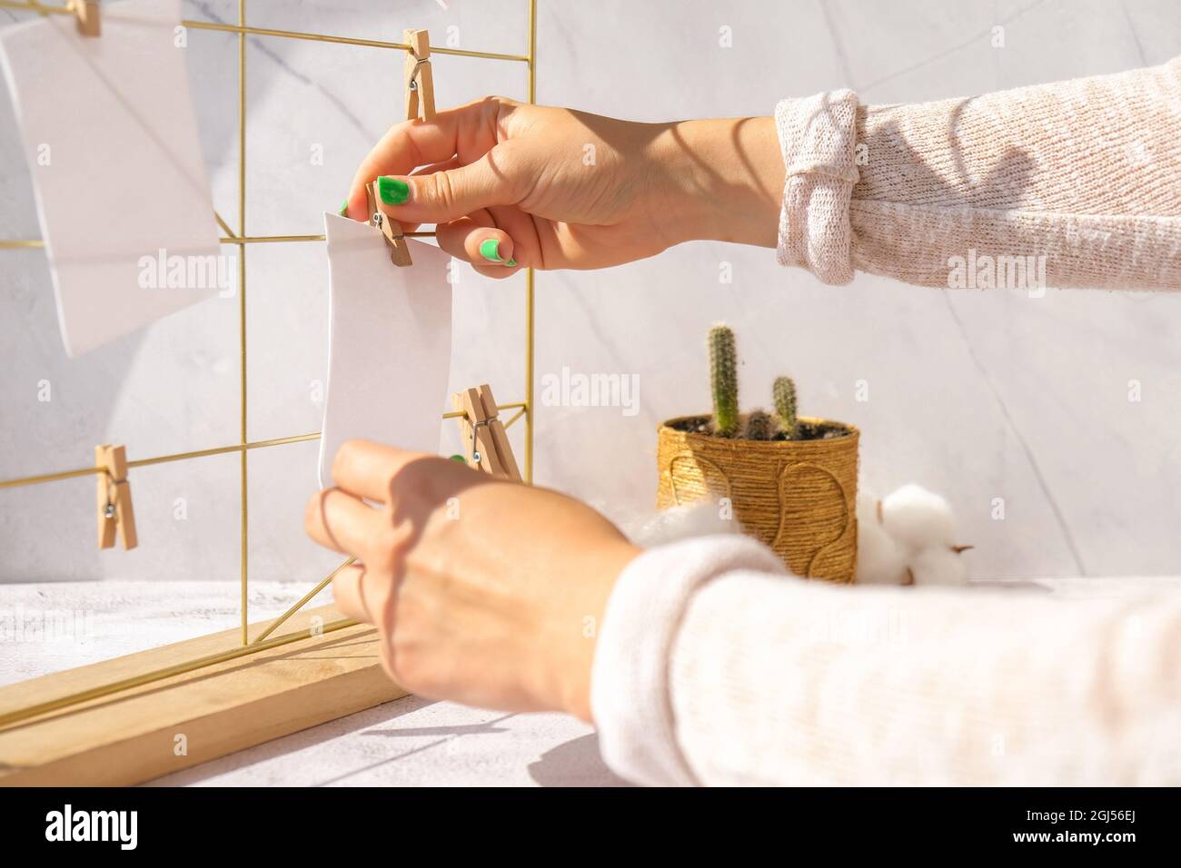 Woman creating mood board. Cards and posters mock ups on grid board