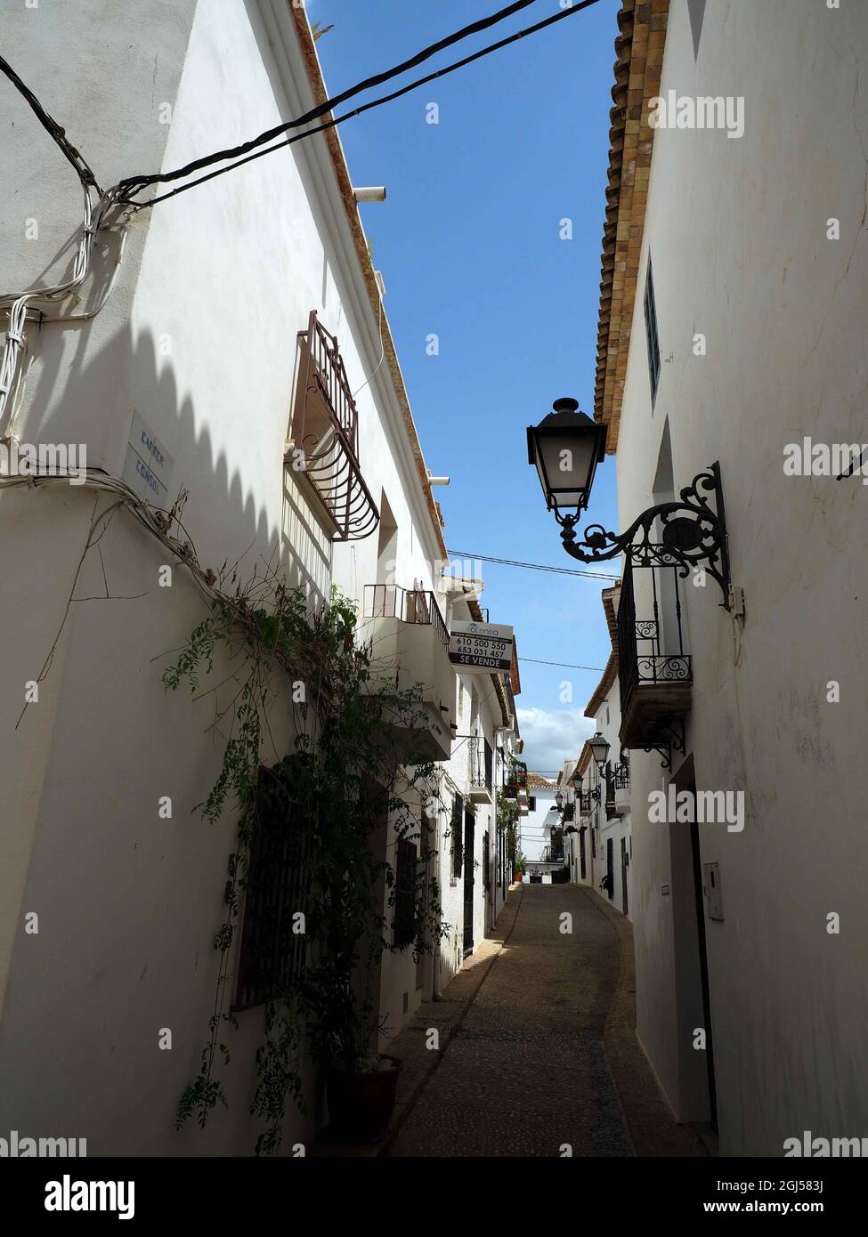 Vertical shot of a narrow alley between white wall buildings in an old ...