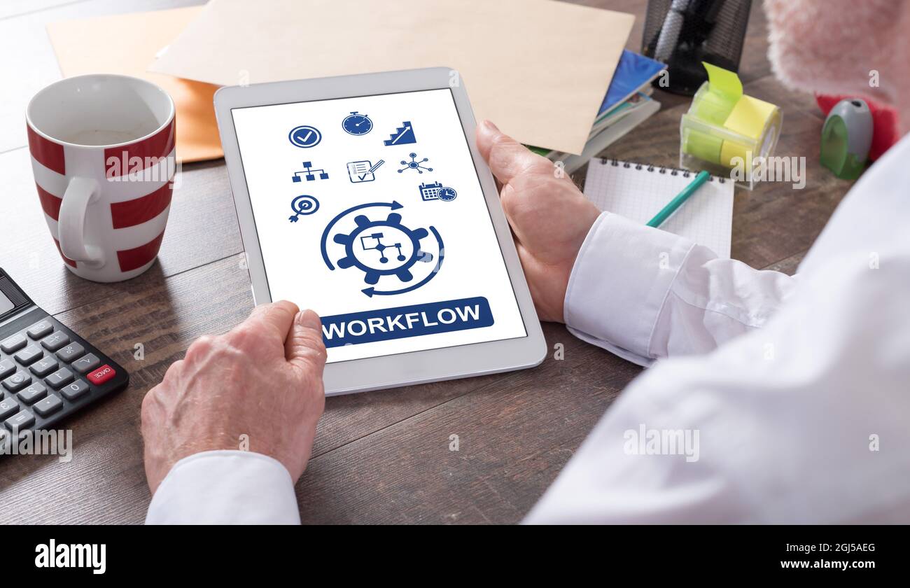 Workflow concept shown on a tablet held by a man Stock Photo