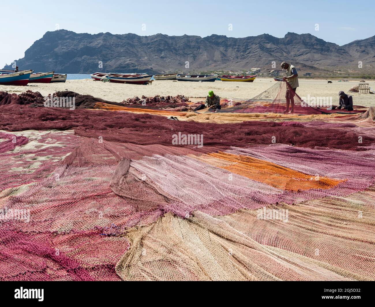 Fishermen are mending their colorful fishing nets on a beach near Sao ...