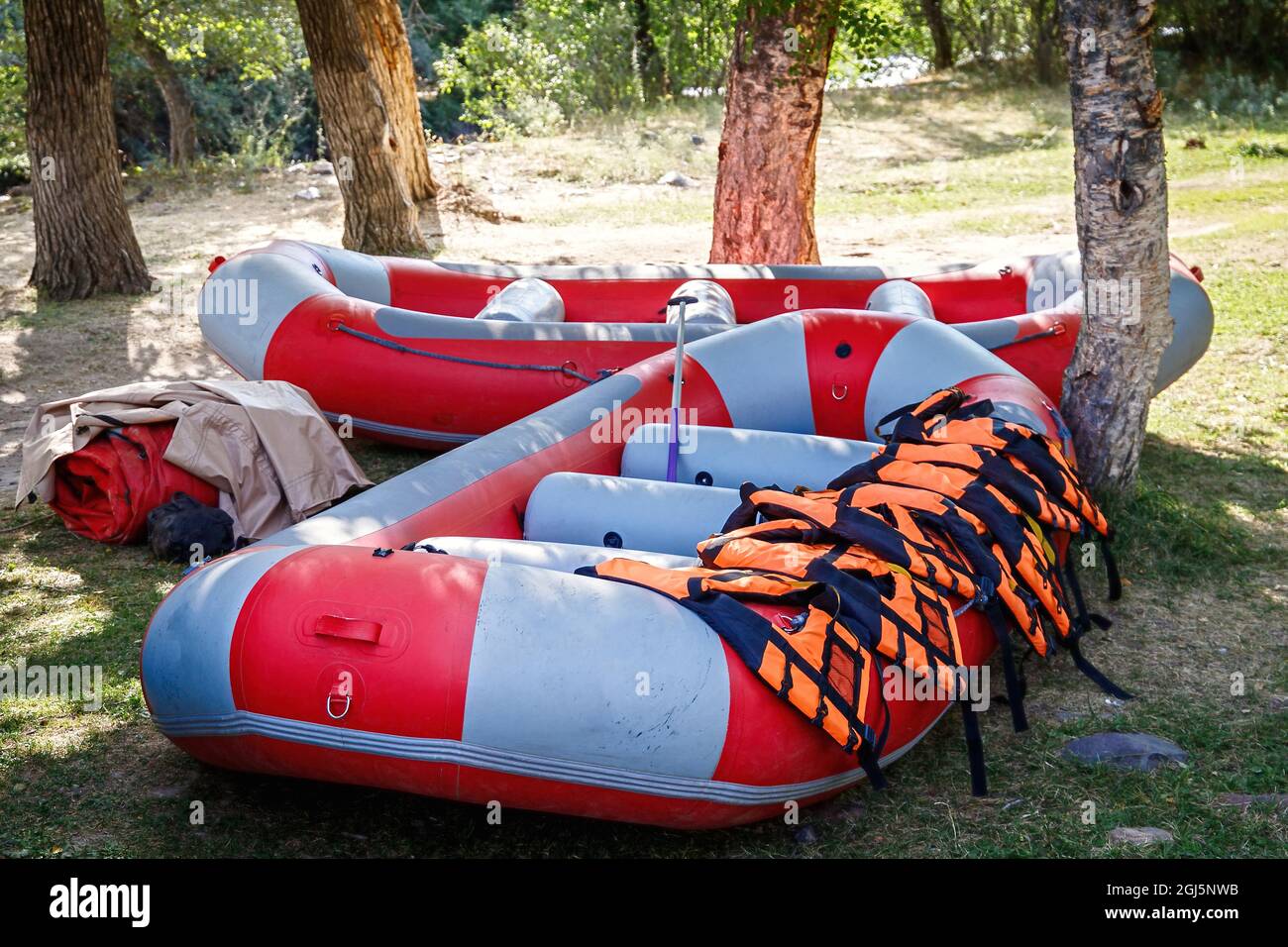 Inflatable rafting boats with equipment stand on the shore in full ...