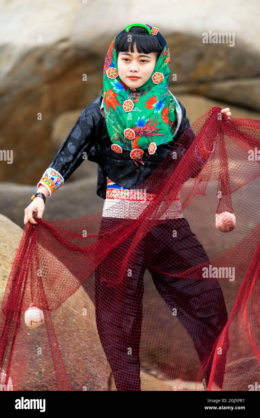 China, Fujian Province, Hui'an. A woman in her native dress holds up a fishing  net. (Editorial Use Only Stock Photo - Alamy