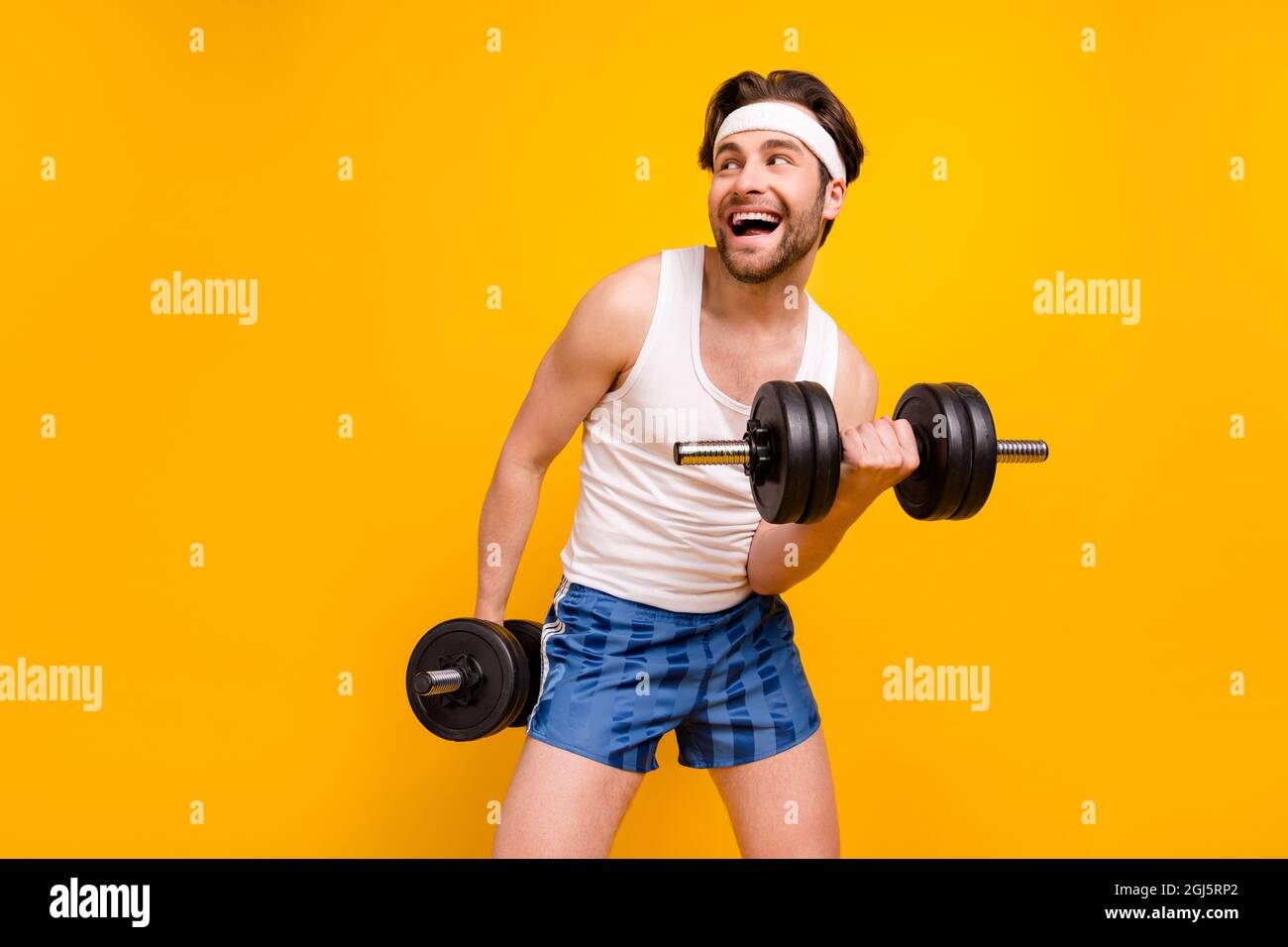 Portrait of attractive cheerful guy lifting weight working out active