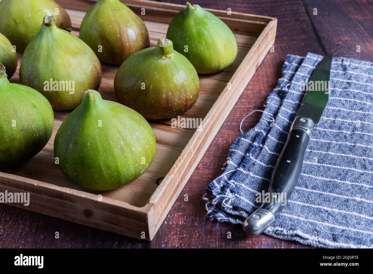 Various green figs on wooden tray Stock Photo