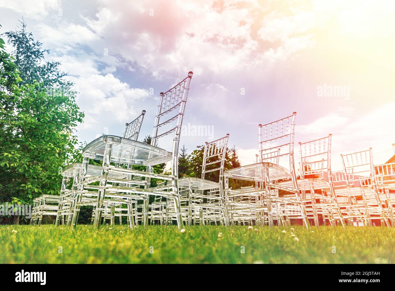 Transparent elegant stylish plastic chairs. Luxury decor for the outdoor wedding ceremony. Stock Photo