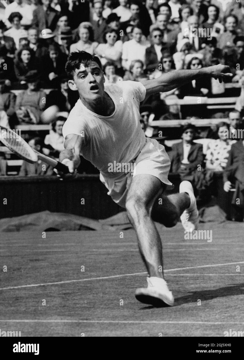 Sweet One From Candy . London : D . W . candy , of Australia , runs across the Centre Court to take a ball from E . W . Sturgess , of South Africa , during their singles match in the Wimbledon Lawn Tennis Championship , played at the All - England Club , Wimbledon . June 27th 1951 Stock Photo