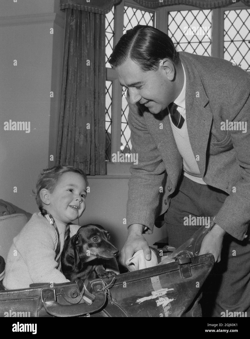 Colin Cowdrey with his son Christopher and the pet dog Dachund Solly at home in Petts Wood Kent packing for the MCC West Indi Cricket Tour December 1959 Stock Photo