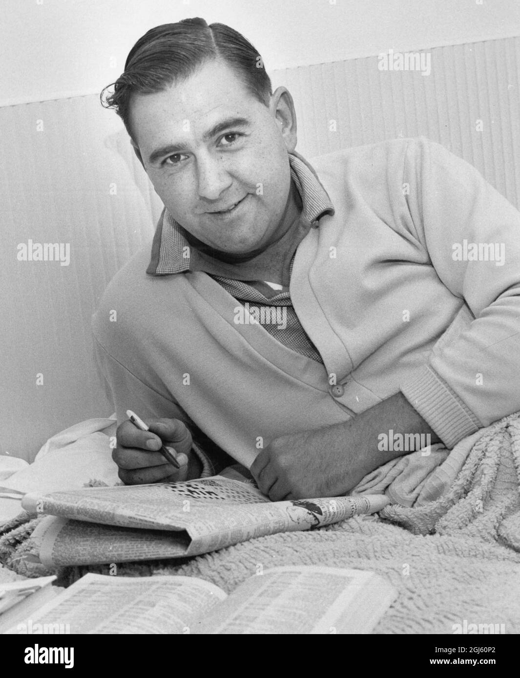 Colin Cowdrey at home in Bickley recovering from the after effects of his recent operation doing the crossword in newspaper July 1962 Stock Photo