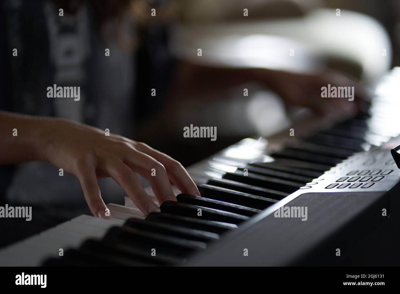 The musician's hands on the synthesizer. A cropped image of a person playing a synthesizer. Side view. High quality photo Stock Photo