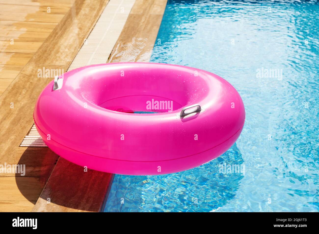 Pink Inflatable ring floating in swimming pool. Refreshing blue water ...