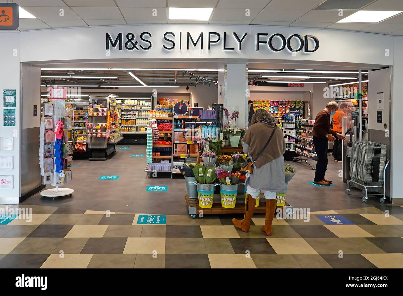 Marks & Spencer sign Simply Food shop a retail business in M5 motorway services shopping mall shoppers in Covid face masks West Midlands England UK Stock Photo