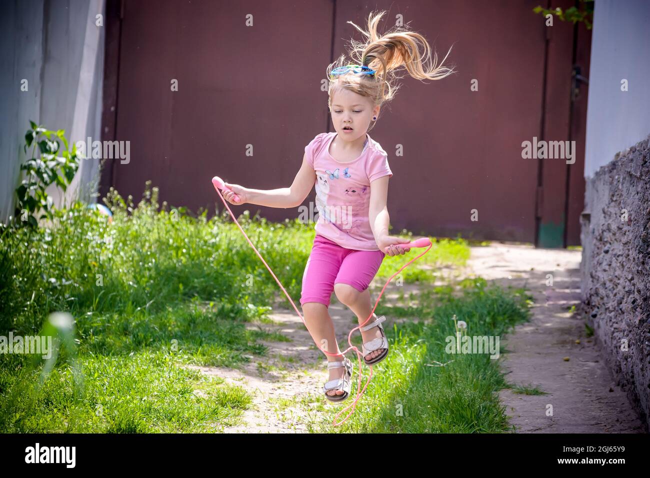 Girl jumping rope on the street Stock Photo