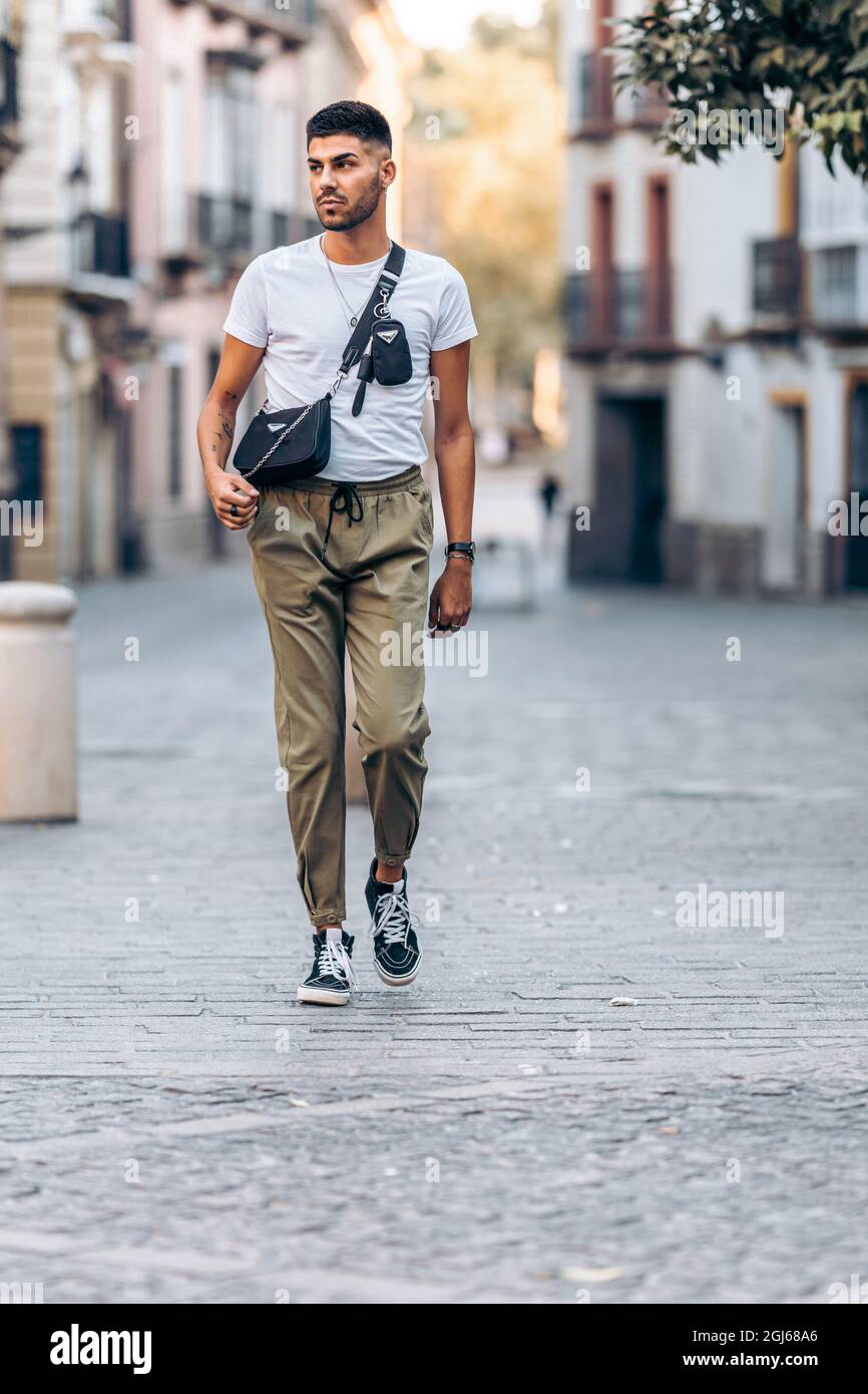 Man walking distracted through the street the street dressed in casual clothing Stock Photo