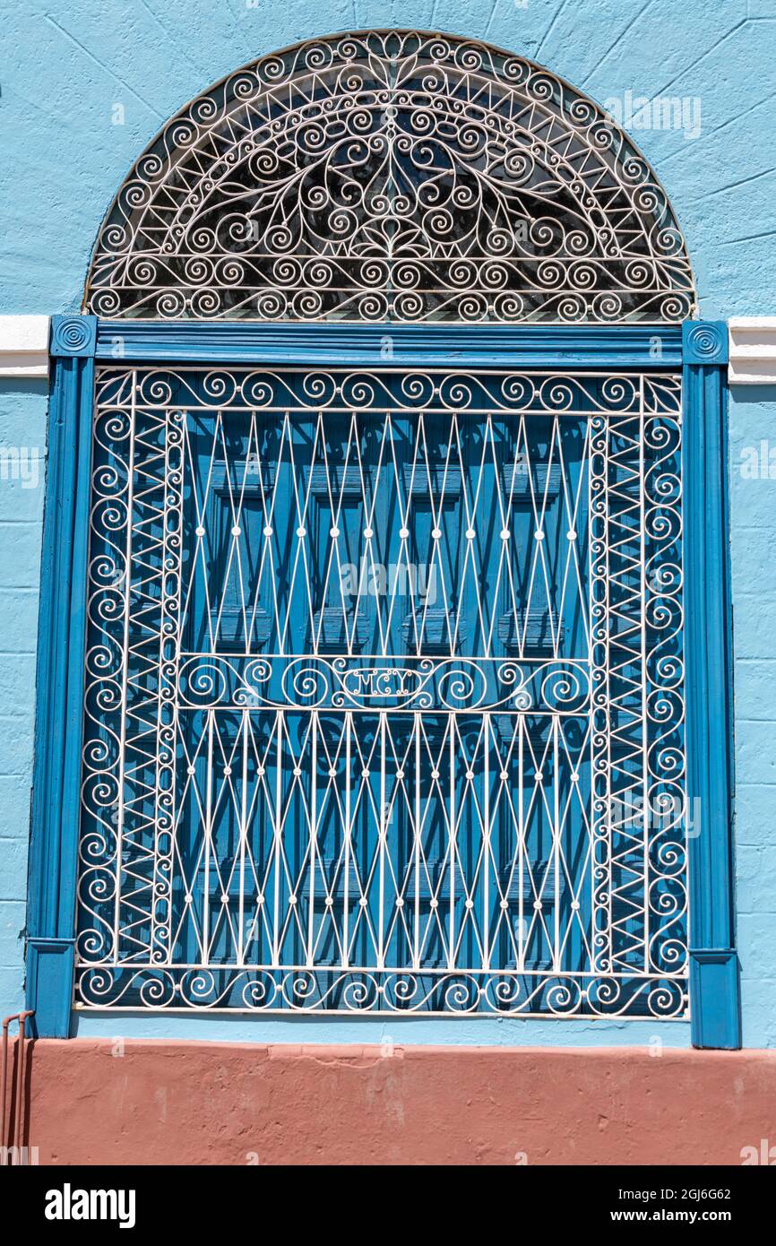Ornate wrought iron covering on blue wooden window shutters, Trinidad