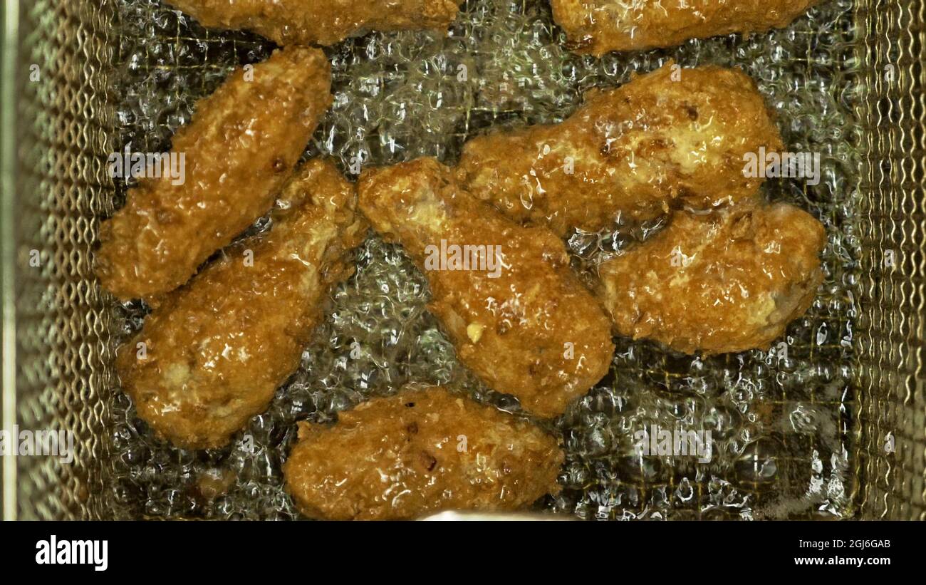 Fast food. Deep fryer with boiling oil and chicken. Large, deeps fryed