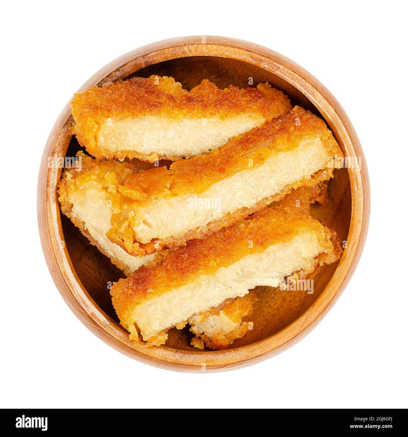 Deep-fried vegan schnitzel slices, in a wooden bowl. Fried cutlets, based on soy protein, a meat substitute, with crispy breading, cut into slices. Stock Photo