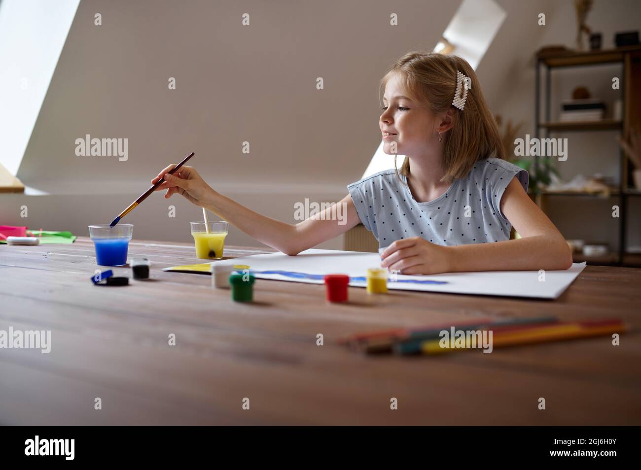 Little girl drawing with brush and paints Stock Photo - Alamy