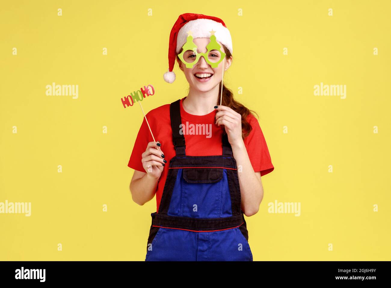 Funny handy woman having fun, trying on christmas party masks on stick
