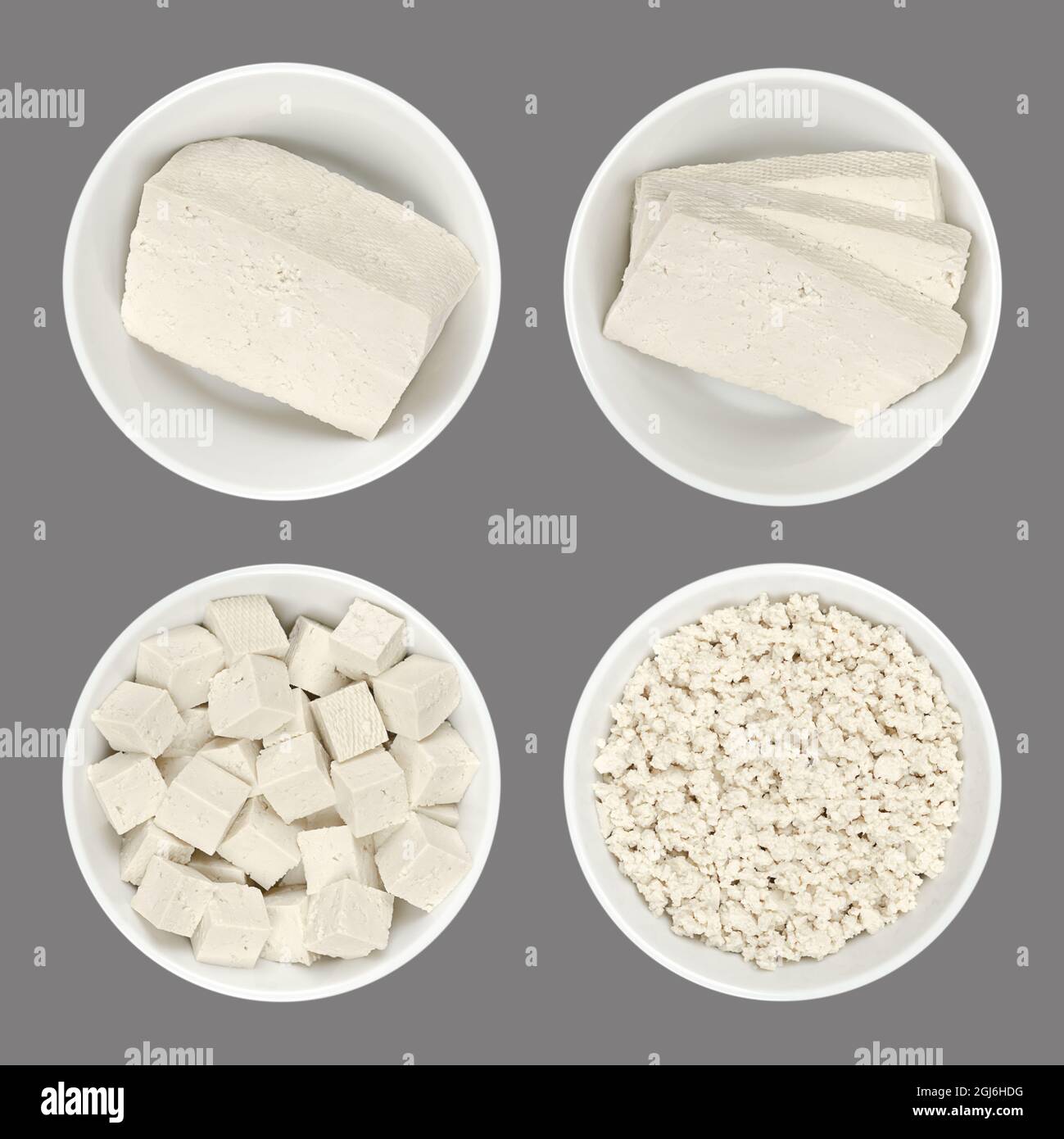 Processed white tofu, in white bowls, isolated on gray background. A block, slices,  cubes, and crumbled tofu. Bean curd, made of coagulated soy milk. Stock Photo