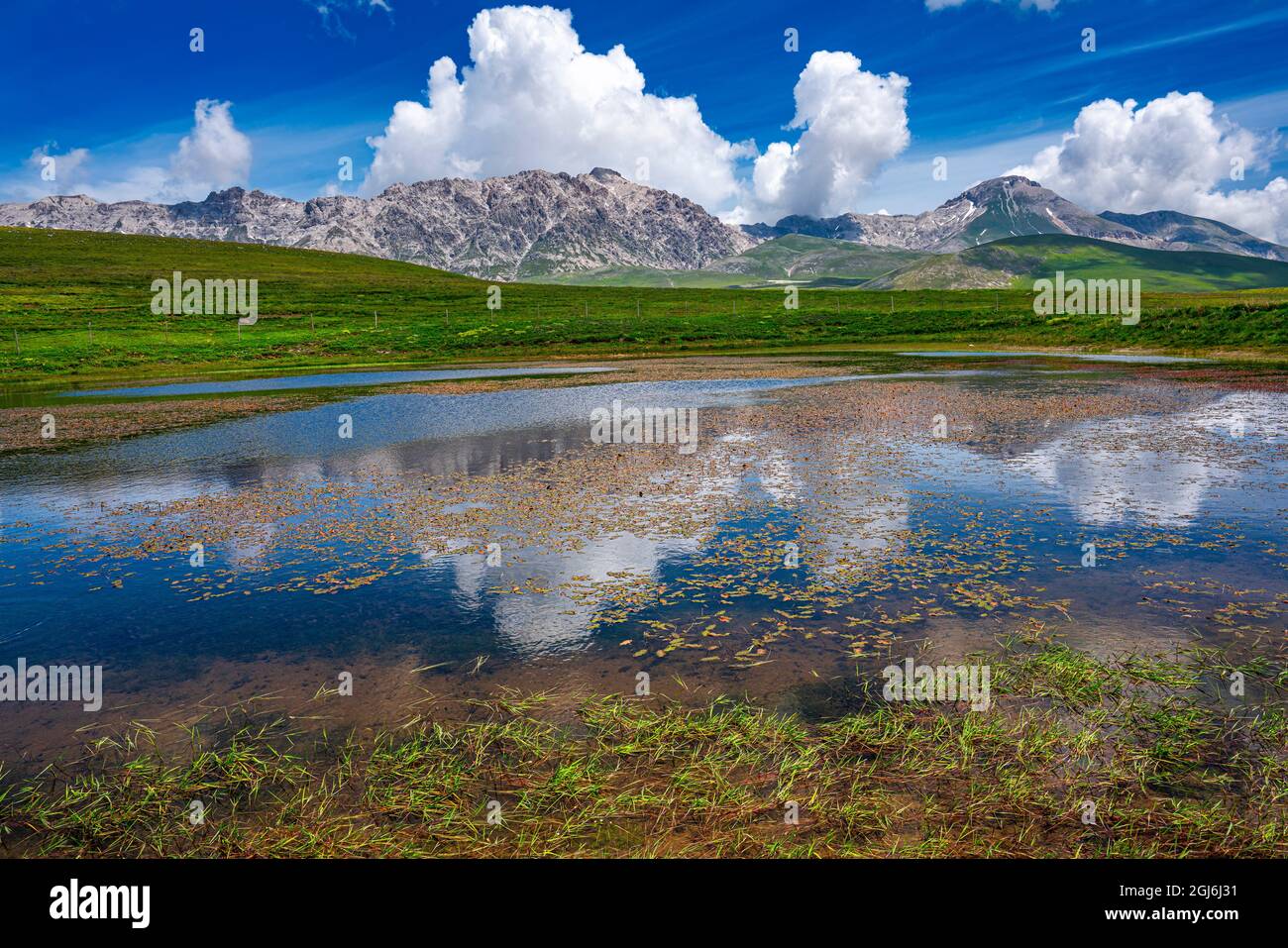the Gran Sasso chain is reflected in the Racollo lake in summer. Gran Sasso and Monti della Laga national Park, Campo Imperatore, Abruzzo Stock Photo