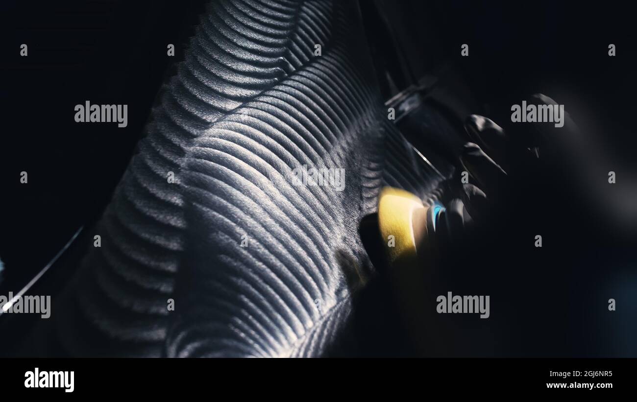 The process of polishing a hood car. View side. Man worker polishes bonnet auto with polish machine. Beautiful wave trace from the polishing fluid pas Stock Photo
