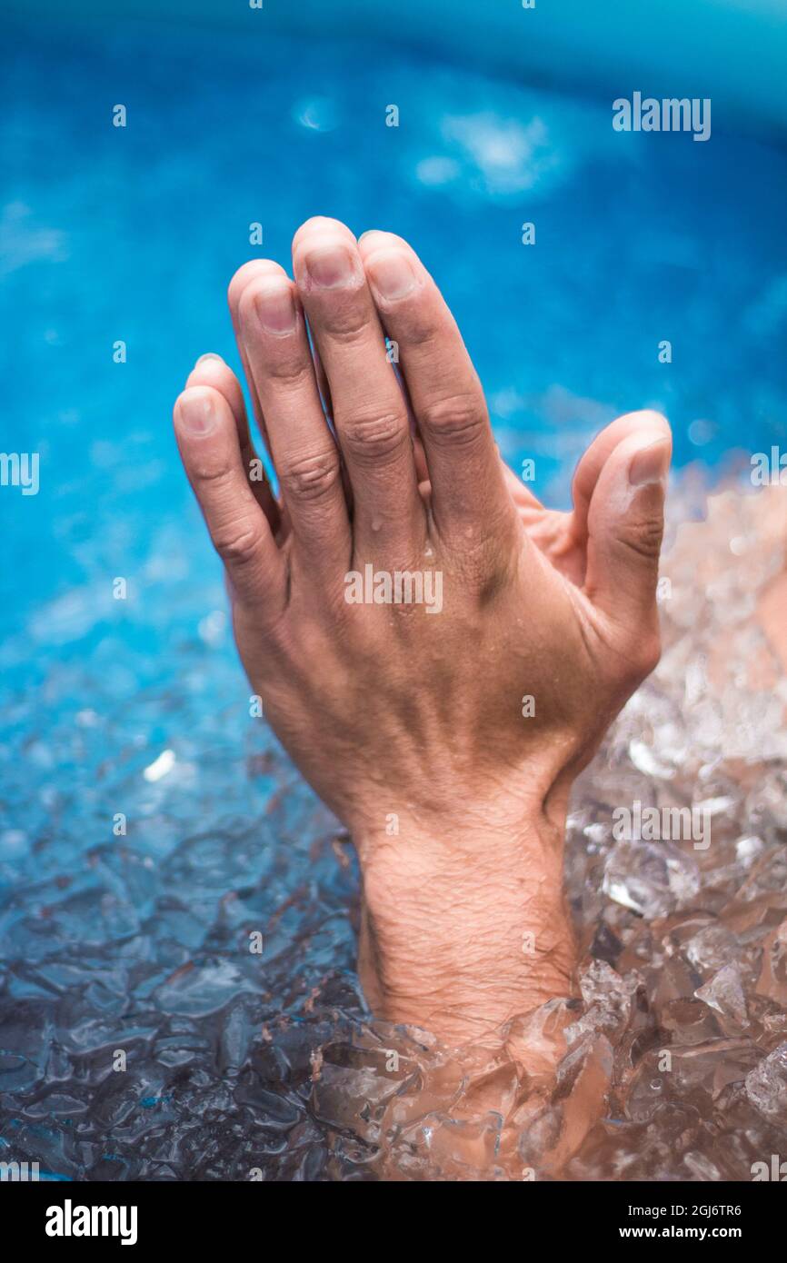 Close up shot to hands of a man coming out from under water while