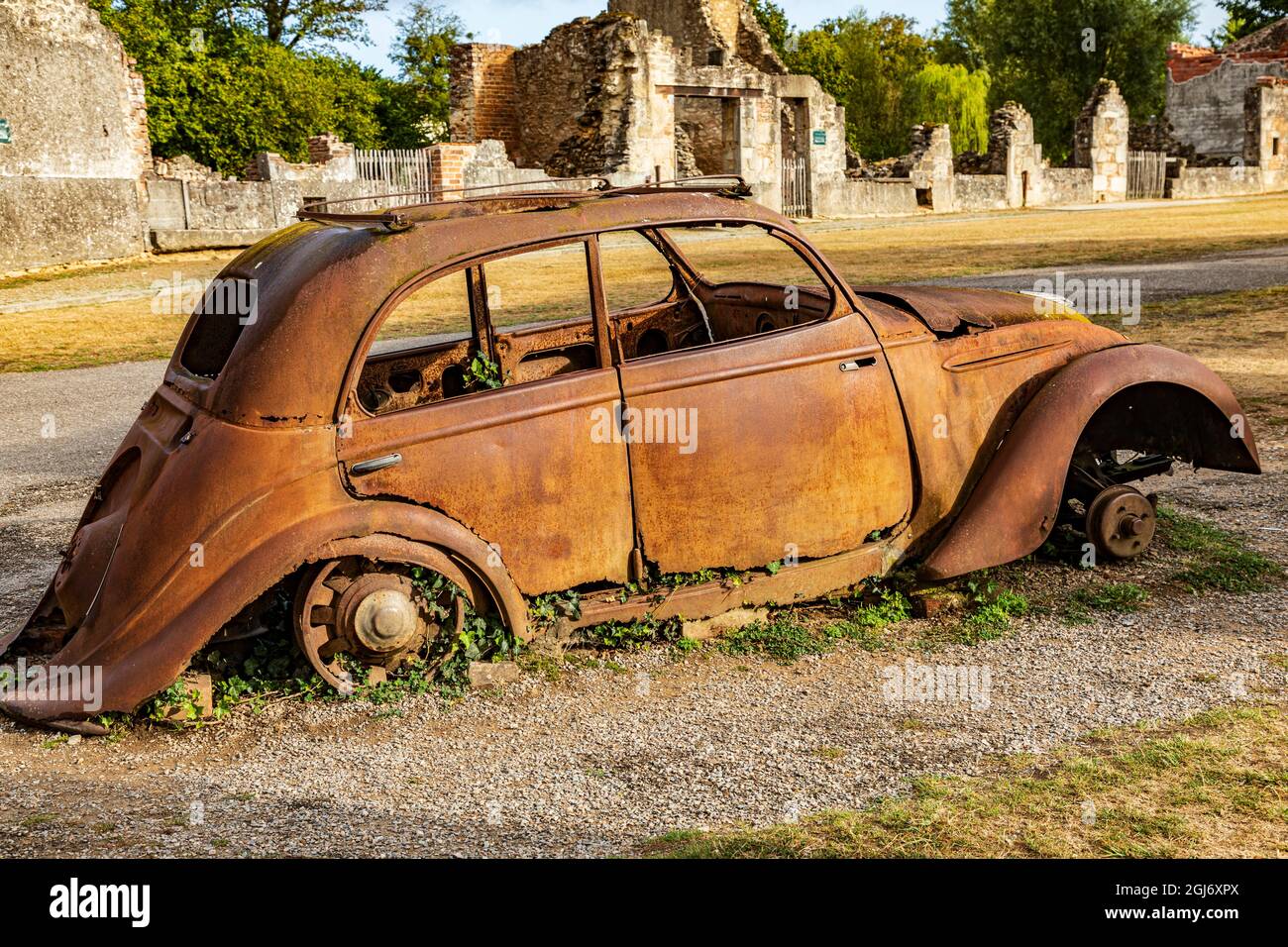 Europe, France, Haute-Vienne, Oradour-sur-Glane. Rusted car in the