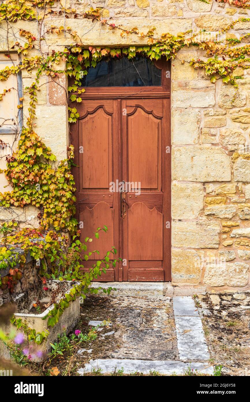 Europe, France, Dordogne, Hautefort. Brown door in a stone house in the town of Hautefort. Stock Photo