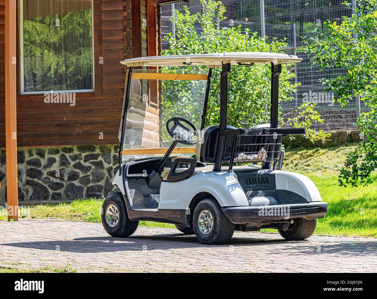 A Yamaha golf cart in front of a house in Voevodyno, Ukraine. Stock Photo