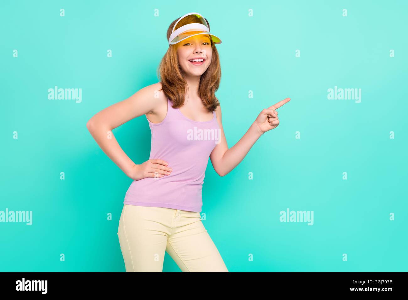 Photo portrait girl smiling cheerful wearing cap headband showing copyspace isolated vivid teal color background Stock Photo