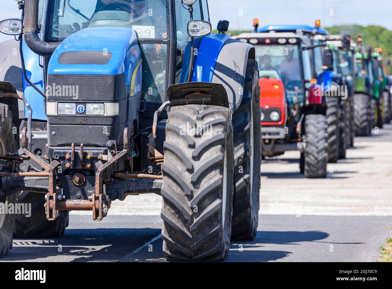 A line of tractors commence a tractor run, commonly held in rural areas