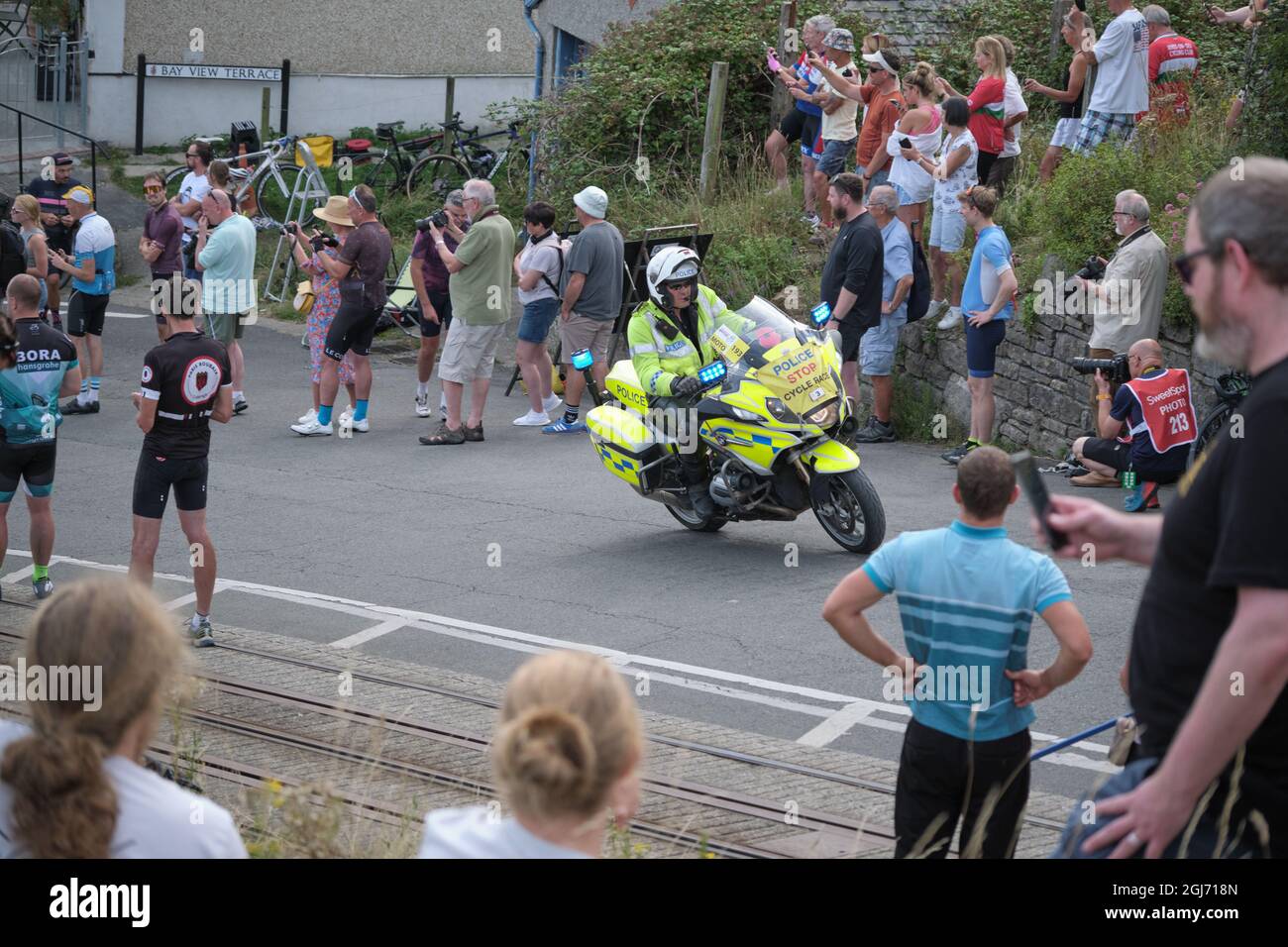 Police escort precedes the riders arrival on the Great Orme, Llandudno for the finish of the Tour of Britain 2021 Stage 4 Stock Photo