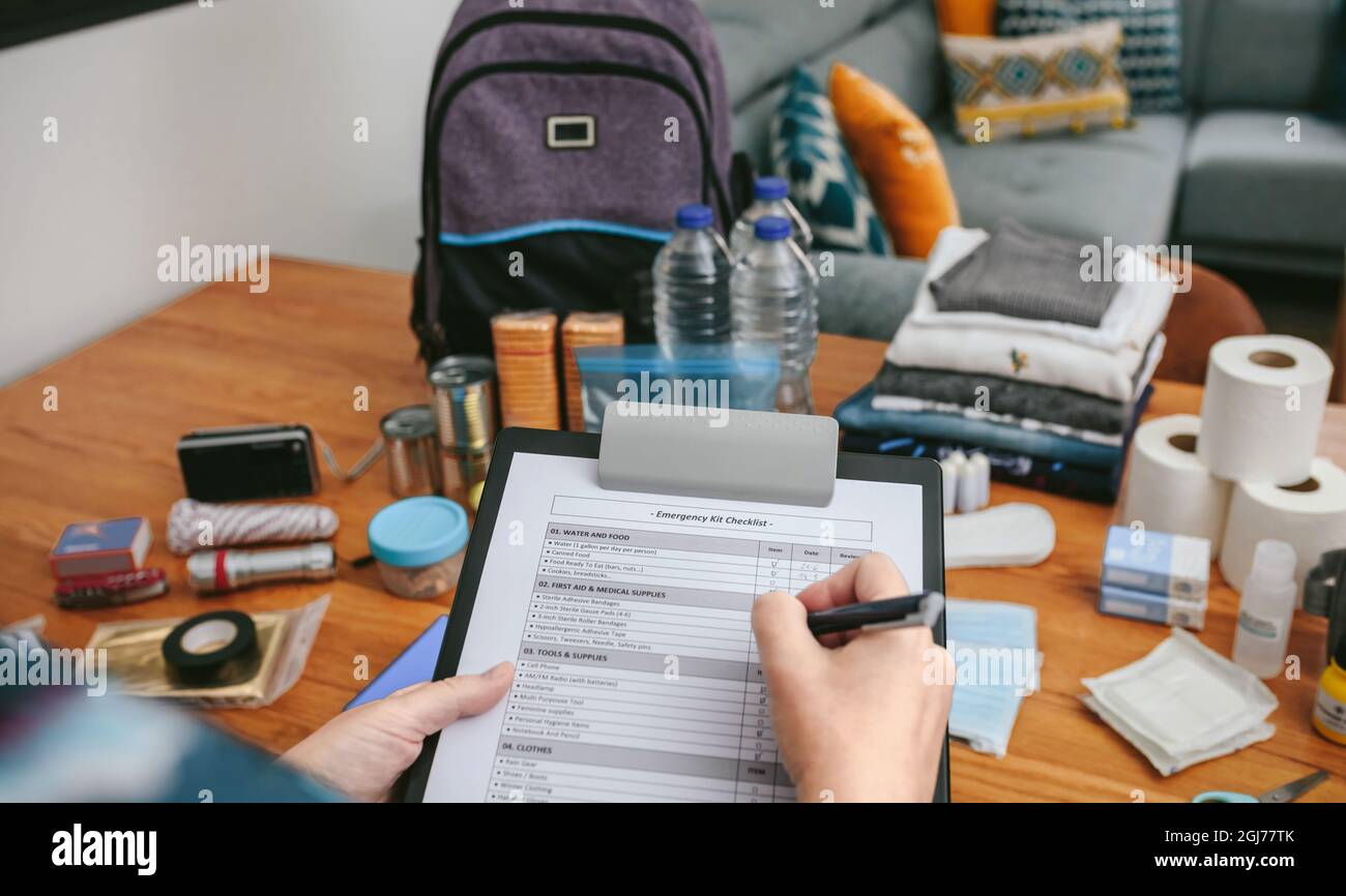 Woman doing checklist of emergency backpack Stock Photo Alamy