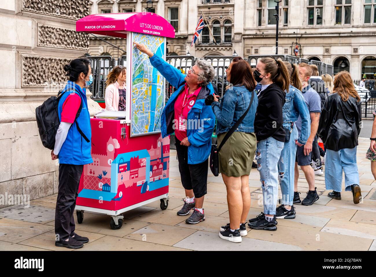 Team London Ambassadors Help Visitors To London By Giving Them Directions On A Map, Parliament Square, London, UK Stock Photo