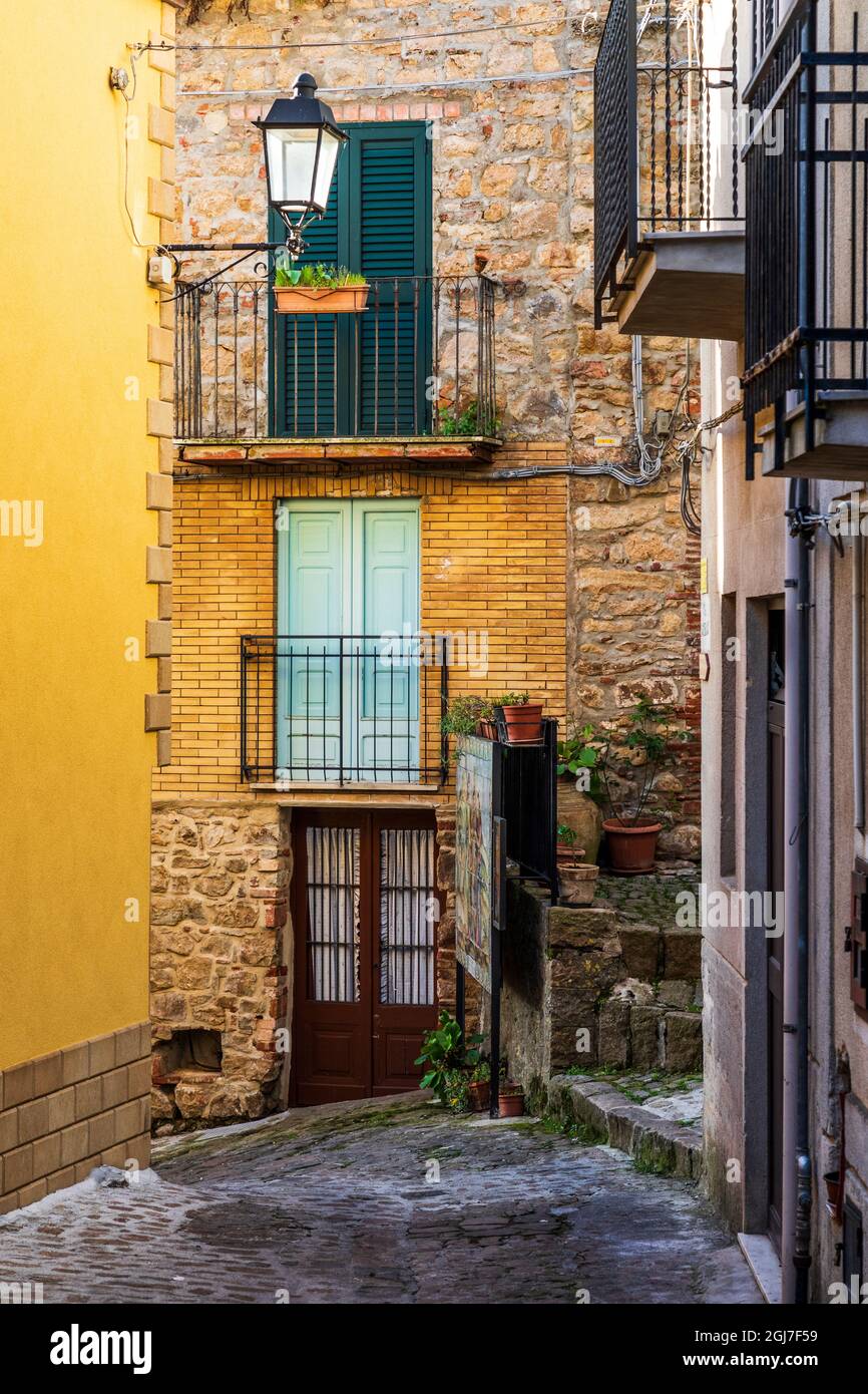 Italy, Sicily, Palermo Province, Pollina. Balconies above a cobblestone city street in Pollina. Stock Photo