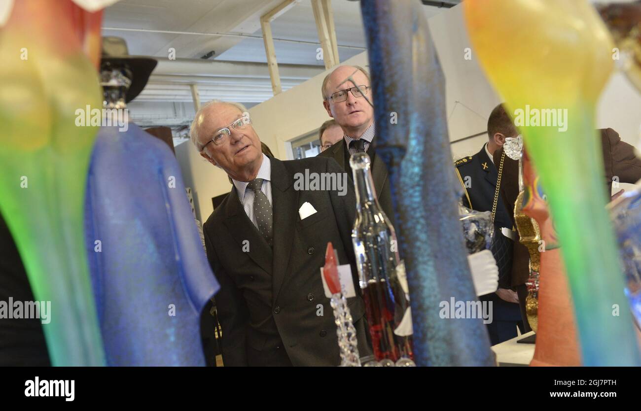 King Carl Gustaf of Sweden is seen studying a piece of glass art of the desigtner Kjell Hoglund at the Kosta Boda glassworks near Nybro, Sweden March 6, 2013.    Stock Photo
