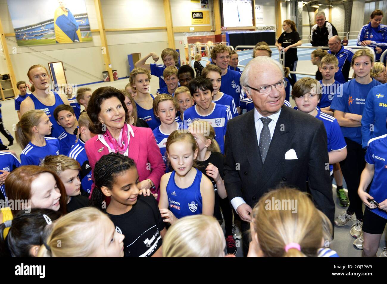 King Carl XVI Gustaf and Queen Silvia of Sweden are surrounded by young athletes during a visit to Vaxjo, Sweden, March 6, 2013.    Stock Photo