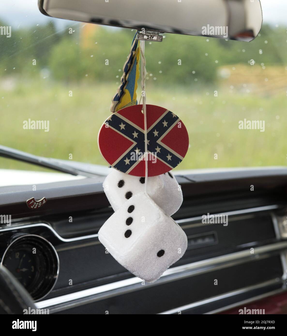 Fuzzy Dice Hanging From a Rear-View Mirror in Vintage Car Stock