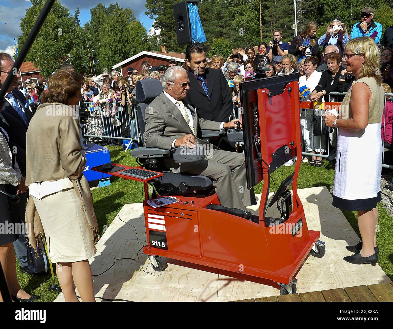 LYCKSELE 2013-08-15 Queen Silvia looks on while King Carl Gustaf is testing a model of a timber machine during their visit to the city of Lyckseled, north Sweden, August 15, 2013. The visit is a part of the KingÂ’s 40 year anniversary on the throne. Foto Jonas Ekstromer / SCANPIX kod 10030  Stock Photo