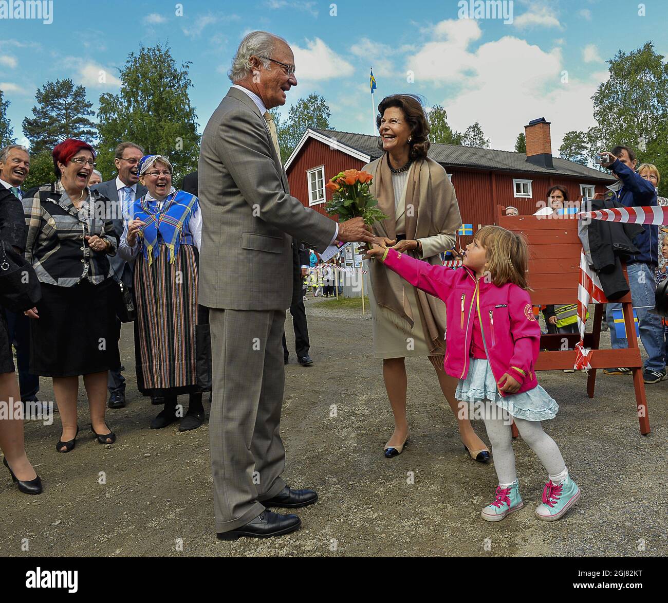 LYCKSELE 2013-08-15 King Carl Gustaf and Queen Silvia are receiving flowers from miss Frida Molin during their visit to the city of Lyckseled, north Sweden, August 15, 2013. The visit is a part of the KingÂ’s 40 year anniversary on the throne. Foto Jonas Ekstromer / SCANPIX kod 10030  Stock Photo