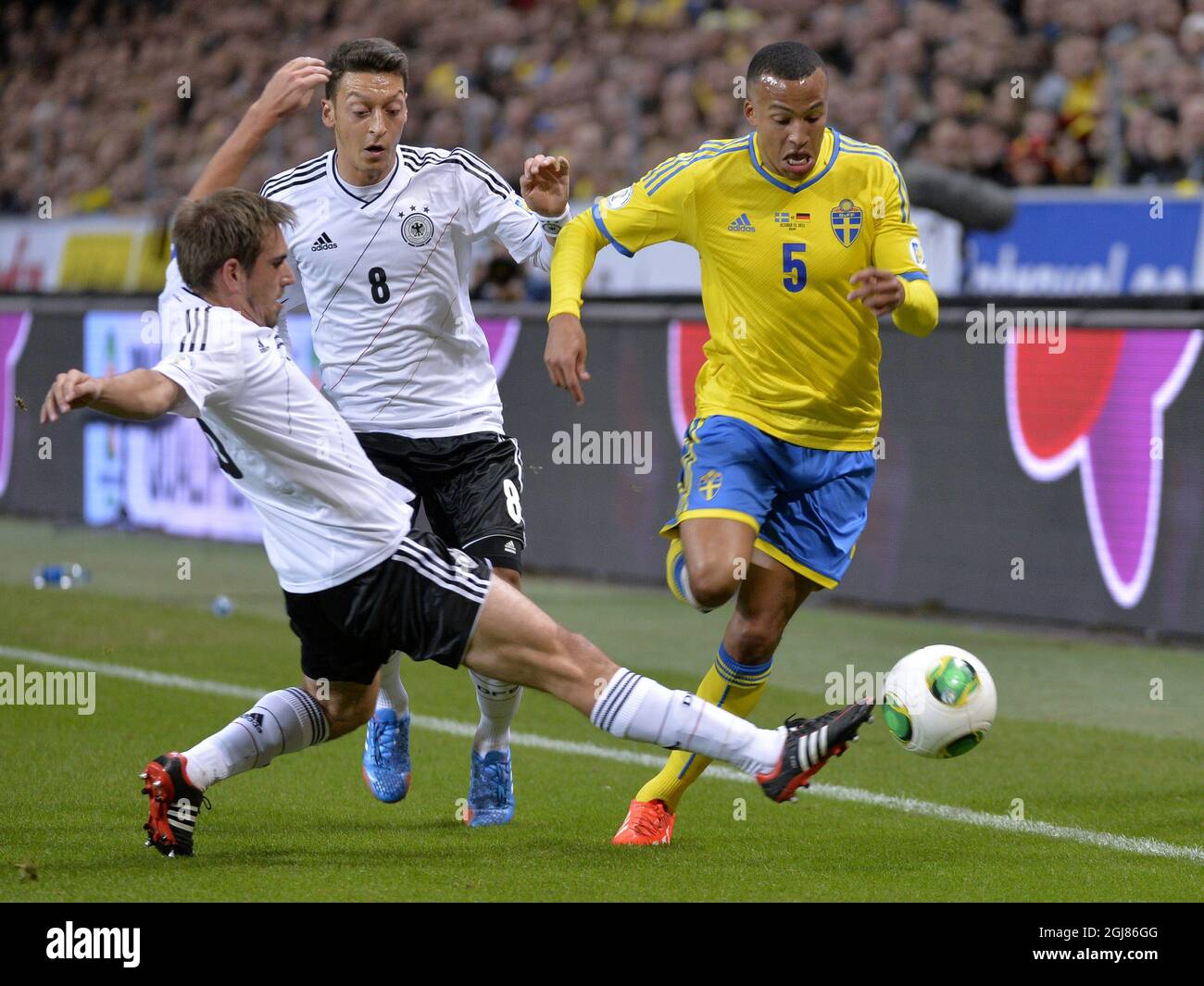 Germany's Philipp Lahm (L) and Mesut Oezil (C) vie with Sweden's Martin Olsson during the 2014 World Cup group C qualifying soccer match between Sweden and Germany at Friends Arena in Stockholm, Sweden, on Oct. 15, 2013. Photo: Anders Wiklund / TT / code 10040  Stock Photo