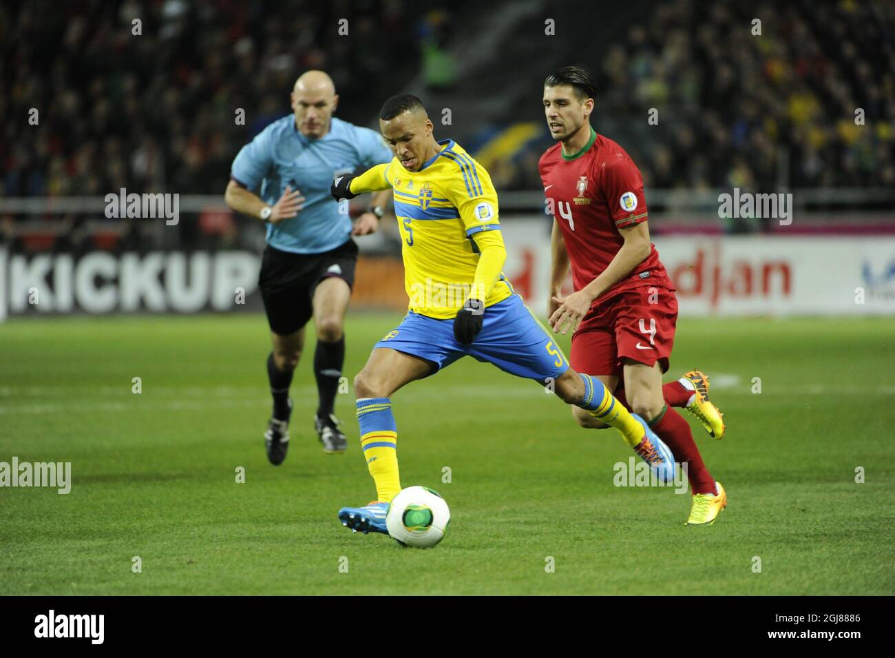 Sweden's Martin Olsson (L) is chased by Portugals Miguel Veloso during the FIFA World Cup 2014 qualifying playoff second leg soccer match between Sweden and Portugal at Friends Arena in Stockholm on Nov. 19, 2013. Photo: Erik Martensson / TT / code 10400 Stock Photo