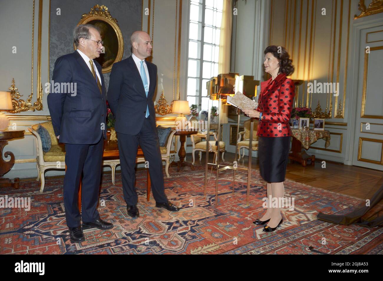 STOCKHOLM 2013-12-18 Queen Silvia together with the Speaker of the Parliament Per Westerberg and Prime Minister Fredrik Reinfeldt standing next to her gift, a brass lamp from Skultuna, given to her by the Parliament and Government of Sweden during a reception in connection with H.M. The Queen's 70th birthday at the Royal Palace in Stockholm, Sweden, December 18, 2013. Foto: Janerik Henriksson / TT / Kod 10010 Stock Photo