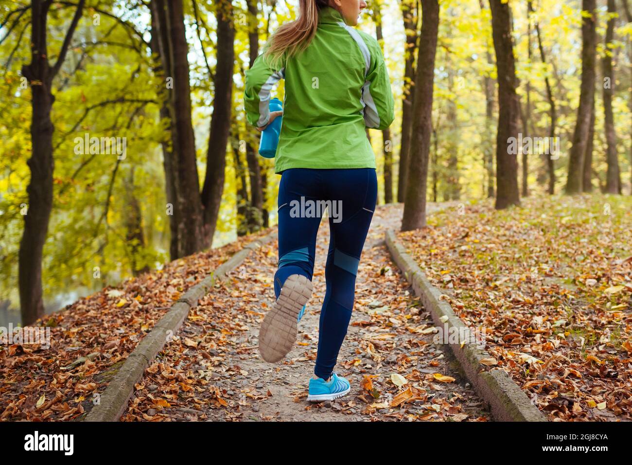 Closeup Slow Motion Shot of Woman in Leggings Running at Forest